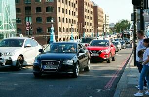 Beautiful Low Angle View of Central London and Road with Traffic and People. The Image Was Captured at Tower Bridge London England Great Britain on Warm Sunny Day of 04-June-2023 photo