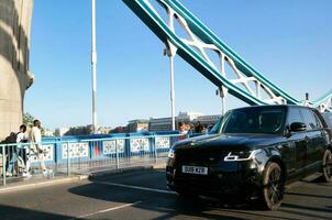 Beautiful Low Angle View of Central London and Road with Traffic and People. The Image Was Captured at Tower Bridge London England Great Britain on Warm Sunny Day of 04-June-2023 photo