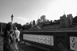 Beautiful Low Angle View of Central London and Road with Traffic and People. The Image Was Captured at Tower Bridge London England Great Britain on Warm Sunny Day of 04-June-2023 photo