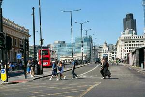 Beautiful Low Angle View of Central London and Road with Traffic and People. The Image Was Captured at Tower Bridge London England Great Britain on Warm Sunny Day of 04-June-2023 photo
