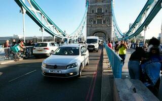 Beautiful Low Angle View of Central London and Road with Traffic and People. The Image Was Captured at Tower Bridge London England Great Britain on Warm Sunny Day of 04-June-2023 photo