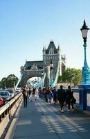 Beautiful Low Angle View of Central London and Road with Traffic and People. The Image Was Captured at Tower Bridge London England Great Britain on Warm Sunny Day of 04-June-2023 photo