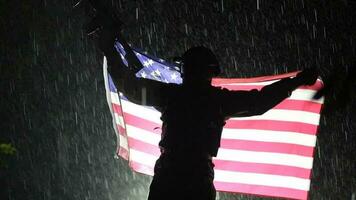 orgulhoso americano exército soldado com nacional bandeira dentro mãos durante pesado trovoada. lento movimento cenas video