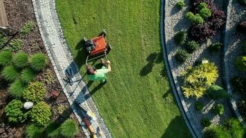 poderoso gasolina césped aireador trabajo para controlador césped paja, y reduciendo suelo compactación patio interior césped campo mantenimiento. caucásico jardinero en su 40 años aéreo vista. video