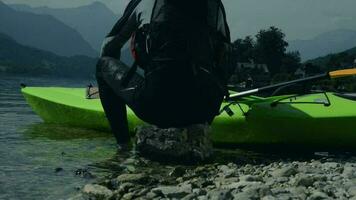 kayaker vilar på de strandlinje sten. Kajakpaddling sport. video