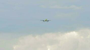 passageiro avião com verde libré Aproximando para terra dentro uma nublado céu, frente Visão video