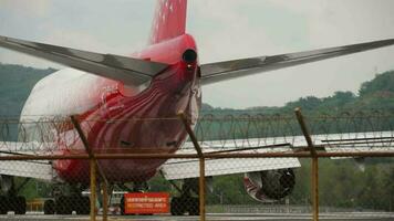 PHUKET, THAILAND NOVEMBER 26, 2017 - Pssenger widebody aircraft Boeing 747 of Rossiya taxiing on runway at Phuket airport, rear view through the fence. Tourism and travel concept video