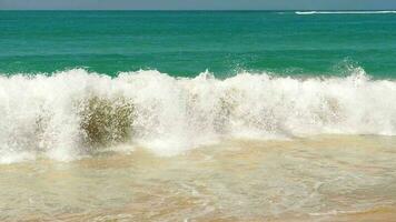 azur olas de el océano. el concepto de un turista vacaciones en el islas grande olas rodar sobre el arenoso apuntalar video