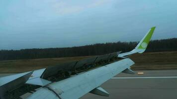 Plane landing. Visible to the runway, the movement of the flap. Video from the window of the passenger cabin