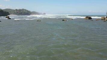 Aerial view of giant ocean waves crashing and foaming in coral beach video