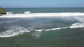 Aerial view of giant ocean waves crashing and foaming in coral beach video