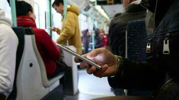 pasajeros de viaje en el subterraneo son utilizando su Los telefonos, el imagen de personas yendo en el rápido tren, público transporte video
