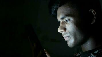 young man sitting on bed using smart phone at night video