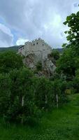 Castle Kastelbell viewed from below. The Castle sits on a rock above Orchards in the Vinschgau valley in South Tyrol, Italy video