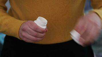 gul piller falla på en kvinna handflatan från flaska av piller. närbild video