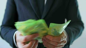 Formally dressed man counting euro banknotes, close-up video