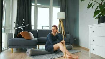 Woman sits in the middle of the room deep in thought. She needs to clean up, but she procrastinates video