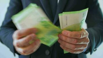 Formally dressed man counting euro banknotes, close-up video