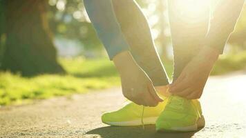 vrouw koppelverkoop schoenveters terwijl jogging of wandelen Bij zonsondergang video