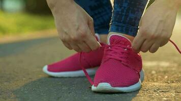 kvinna kvitt skosnören medan joggning eller gående på solnedgång video