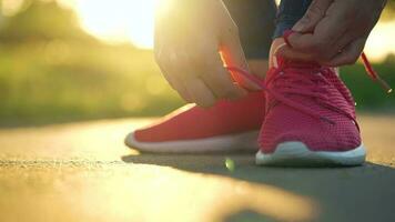 mujer atadura cordones de los zapatos mientras trotar o caminando a puesta de sol video