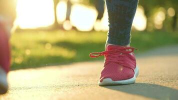 Frau binden Schnürsenkel während Joggen oder Gehen beim Sonnenuntergang video