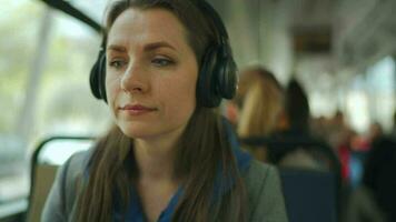público transporte. mulher com fone de ouvido dentro eléctrico usando Smartphone video