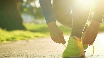 Frau binden Schnürsenkel während Joggen oder Gehen beim Sonnenuntergang video