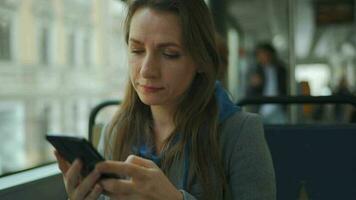 Public transport. Woman in tram using smartphone video