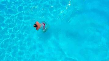 aéreo ver de un hombre en rojo pantalones cortos nadando en el piscina, lento movimiento video
