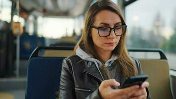 Public transport. Woman in tram using smartphone video