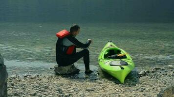 kayakista preparando él mismo antes de kayac excursión en el lago video