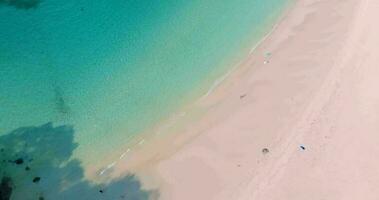 Aerial drone view of clear turquoise sea and waves over the beach video
