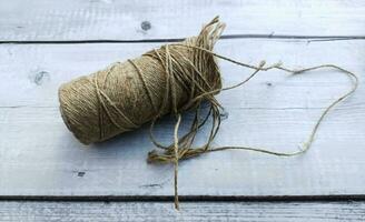 Roll of twine on a white wooden background. photo