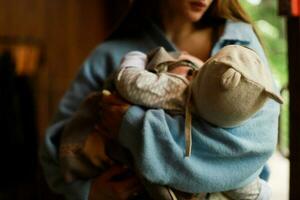 Mom and baby in a cafe. Mom is holding the baby. Baby in a hat with ears photo