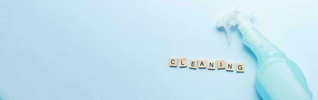 Banner The word cleaning made of wooden letters. Flat lay cleaning spray. Mockup spray photo