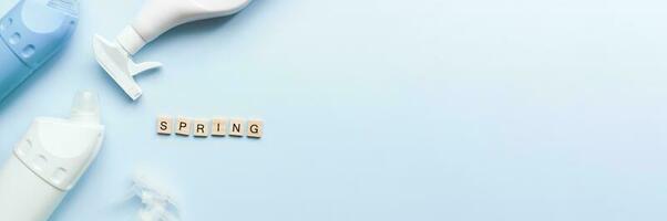 Banner Flat lay spring from wooden letters on a blue background. Cleaners. Cleaning. Cleaning bottle mockup photo