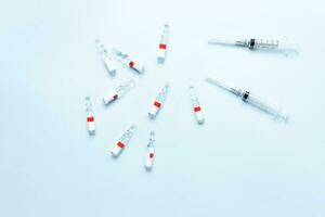 Flat lay ampoules and syringes on a blue background. Medical theme. Vaccination photo