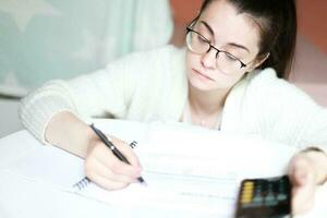 A woman counts debts. Sad woman looking at bills for payment photo