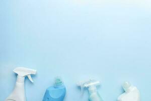 Flat lay housekeeping on a blue background. Cleaning products top view. Cleaning bottle mockups photo