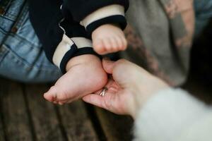 The hand holds the baby is leg. Leg of a newborn. Kid on a walk photo