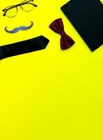 Banner Flat lay fathers day on yellow background. Mockup diary. Tie, glasses, mustache photo