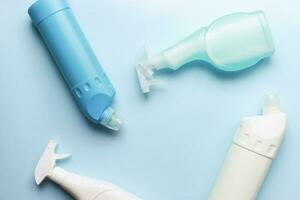 Flat lay different cleaning products on a blue background. Clean bottle mockup photo