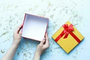 Flat lay hands holding an open gift box. Christmas, glitter. Mockup gift photo