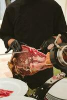 Professional ham carver cutting cured ham slices. photo