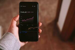 Woman checking financial data of forex trading chart on smartphone. Investment funds in the stock market and digital assets. Business finance technology and investment concept. photo