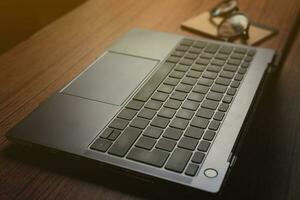 Horizontal desptop photo of laptop on vintage wood desk. Business, finance and gaming concept. Work from home. Workplace.