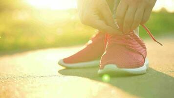 kvinna kvitt skosnören medan joggning eller gående på solnedgång video