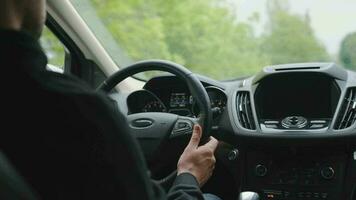 Mens schijven een auto langs de weg in de stad gedurende de regen. visie van achter de bestuurder schouder video