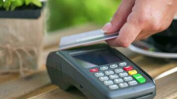 nfc crédito tarjeta pago. mujer pago con sin contacto crédito tarjeta con nfc tecnología a pagar orden en banco terminal en un café video